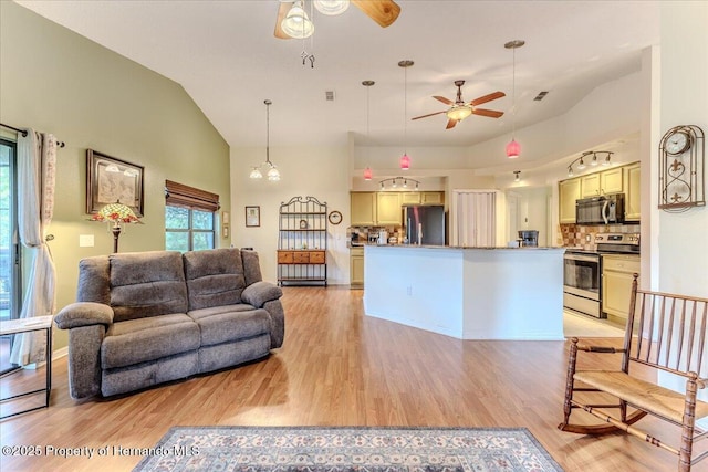 living room with a ceiling fan, light wood-style flooring, and high vaulted ceiling