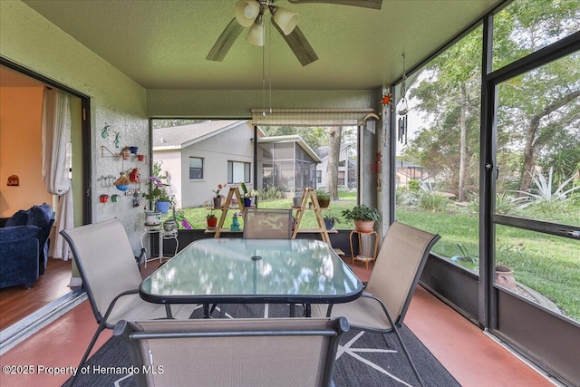 sunroom with ceiling fan and outdoor dining space