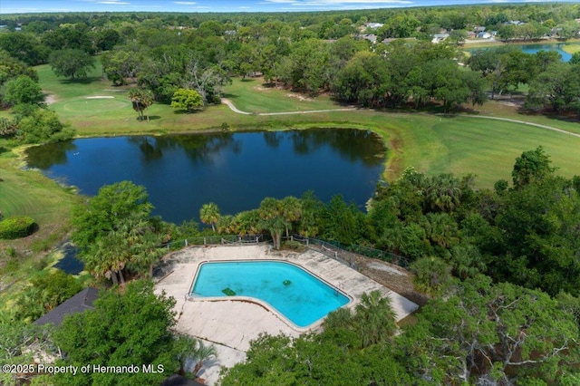 aerial view of property and surrounding area featuring a nearby body of water, a pool area, and a golf course