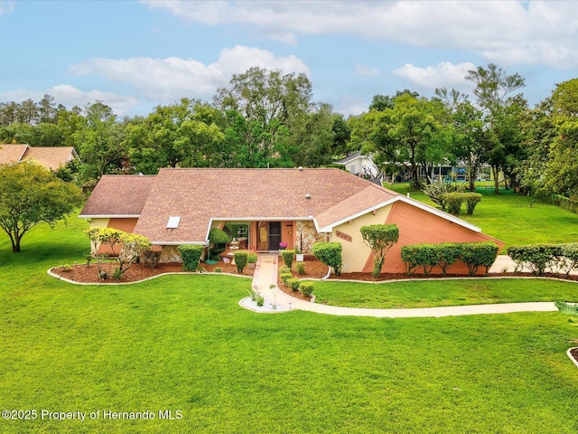 8393 Delaware Dr, Weeki Wachee, FL 34607 - view of front facade featuring a front lawn, covered porch, roof with shingles, and view of wooded area