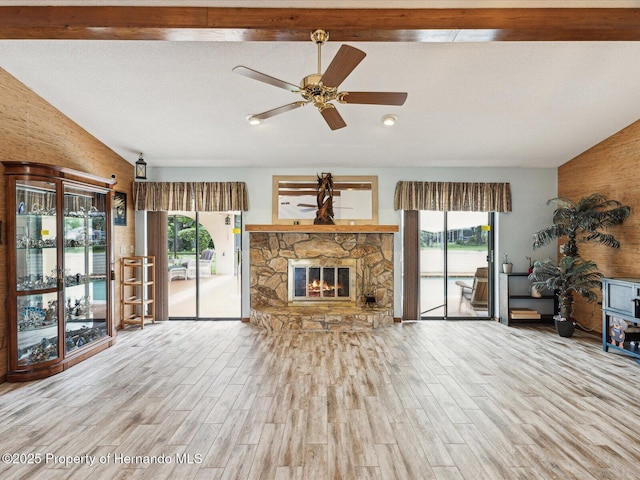 8393 Delaware Dr, Weeki Wachee, FL 34607 - living room with healthy amount of natural light, wood finished floors, ceiling fan, and a stone fireplace