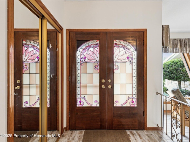 8393 Delaware Dr, Weeki Wachee, FL 34607 - foyer with french doors, light wood-style floors, and baseboards