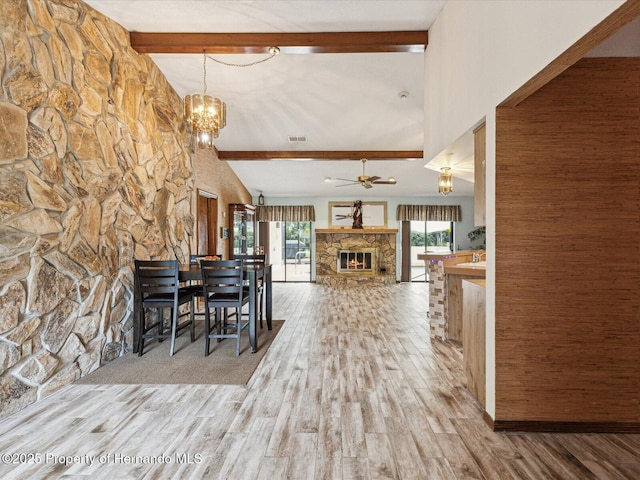 8393 Delaware Dr, Weeki Wachee, FL 34607 - dining space featuring a chandelier, wood finished floors, a stone fireplace, and a ceiling fan