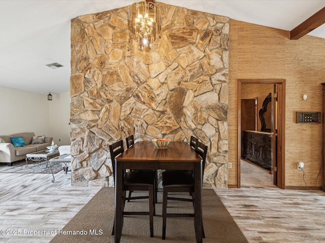 8393 Delaware Dr, Weeki Wachee, FL 34607 - unfurnished dining area featuring wood finished floors, a chandelier, and beam ceiling