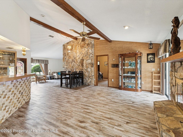 8393 Delaware Dr, Weeki Wachee, FL 34607 - living area featuring a stone fireplace, wood finished floors, and a ceiling fan