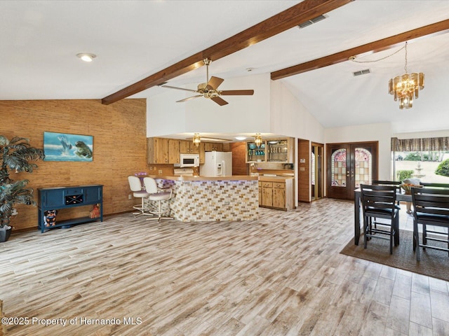 8393 Delaware Dr, Weeki Wachee, FL 34607 - living room with a chandelier, light wood-style floors, beam ceiling, french doors, and ceiling fan