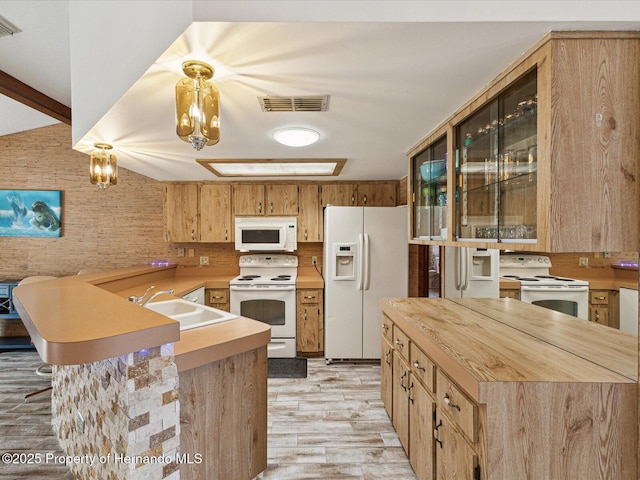 8393 Delaware Dr, Weeki Wachee, FL 34607 - kitchen with white appliances, a sink, light wood-type flooring, a peninsula, and glass insert cabinets