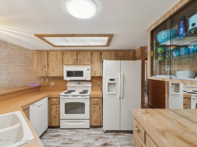 8393 Delaware Dr, Weeki Wachee, FL 34607 - kitchen featuring white appliances, light countertops, light wood finished floors, and a sink