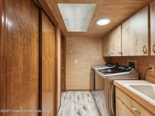 8393 Delaware Dr, Weeki Wachee, FL 34607 - clothes washing area with cabinet space, washer and clothes dryer, light wood finished floors, and wood ceiling