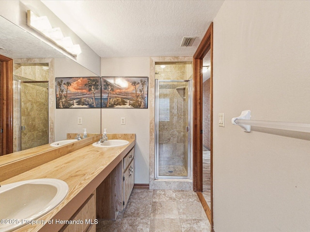 8393 Delaware Dr, Weeki Wachee, FL 34607 - bathroom featuring a textured ceiling, a stall shower, baseboards, and double vanity