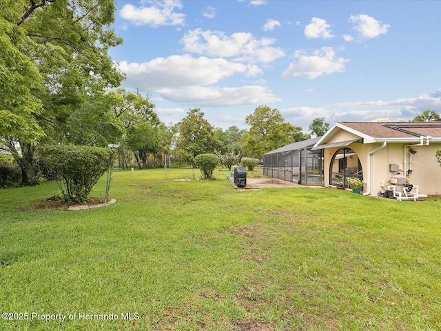 8393 Delaware Dr, Weeki Wachee, FL 34607 - view of green lawn with glass enclosure, a swimming pool, and a patio area