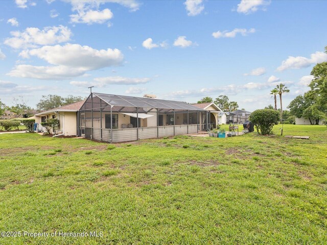8393 Delaware Dr, Weeki Wachee, FL 34607 - back of property with a lawn and a lanai