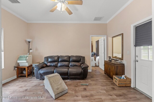 12253 Eskimo Curlew Rd, Brooksville, FL 34614 - living room featuring crown molding, ceiling fan, light wood-type flooring, and baseboards