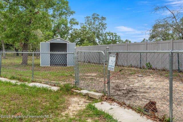 12253 Eskimo Curlew Rd, Brooksville, FL 34614 - fenced backyard with a storage shed, an outdoor structure, and a gate