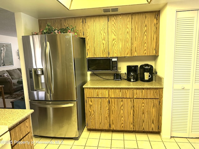 2351 Palm Springs Ct, Spring Hill, FL 34606 - kitchen with stainless steel fridge with ice dispenser, light tile patterned flooring, brown cabinetry, and light countertops