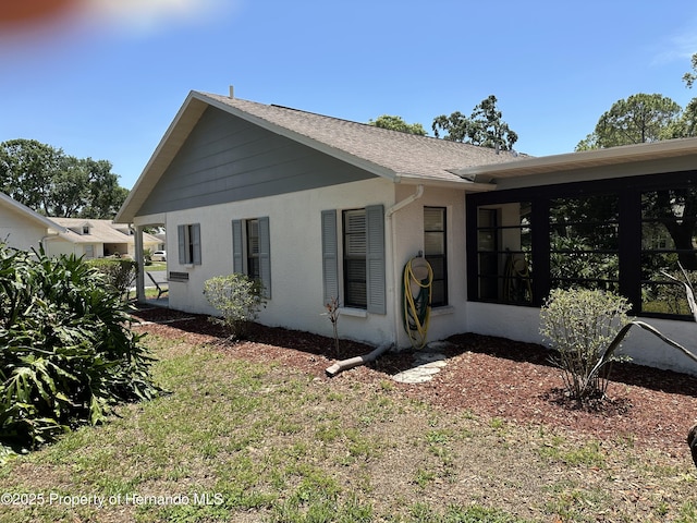 2351 Palm Springs Ct, Spring Hill, FL 34606 - view of side of property featuring stucco siding and a shingled roof