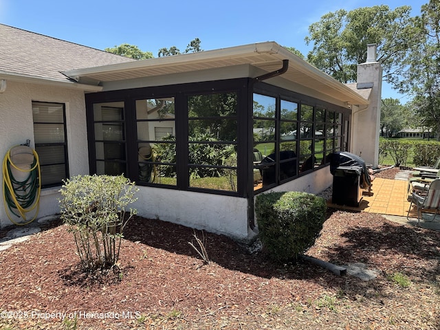 2351 Palm Springs Ct, Spring Hill, FL 34606 - view of side of property featuring a sunroom, a chimney, and roof with shingles
