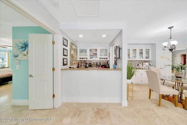 21000 Exeter Ct, Brooksville, FL 34601 - indoor bar with backsplash, a chandelier, recessed lighting, pendant lighting, and baseboards