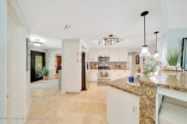 21000 Exeter Ct, Brooksville, FL 34601 - kitchen featuring appliances with stainless steel finishes, light stone counters, white cabinets, and healthy amount of natural light