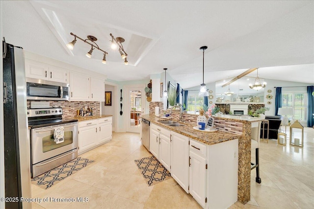21000 Exeter Ct, Brooksville, FL 34601 - kitchen featuring appliances with stainless steel finishes, a sink, decorative backsplash, white cabinetry, and open floor plan