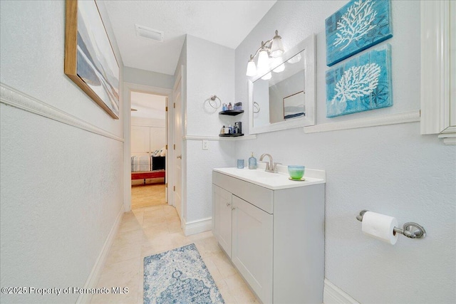 21000 Exeter Ct, Brooksville, FL 34601 - ensuite bathroom with vanity, baseboards, tile patterned flooring, and a textured wall