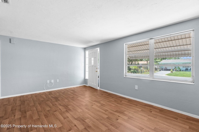unfurnished room with wood finished floors and baseboards