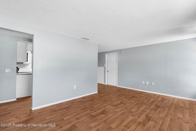 unfurnished room with wood finished floors and baseboards
