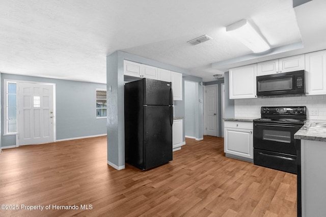 kitchen with black appliances, baseboards, white cabinets, decorative backsplash, and a textured ceiling