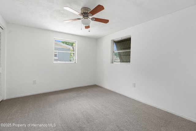 unfurnished room with carpet, a ceiling fan, and baseboards