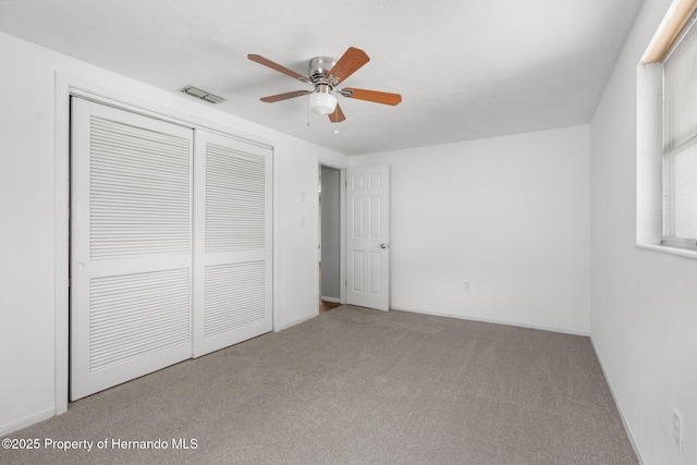 unfurnished bedroom featuring a closet, carpet, ceiling fan, and baseboards