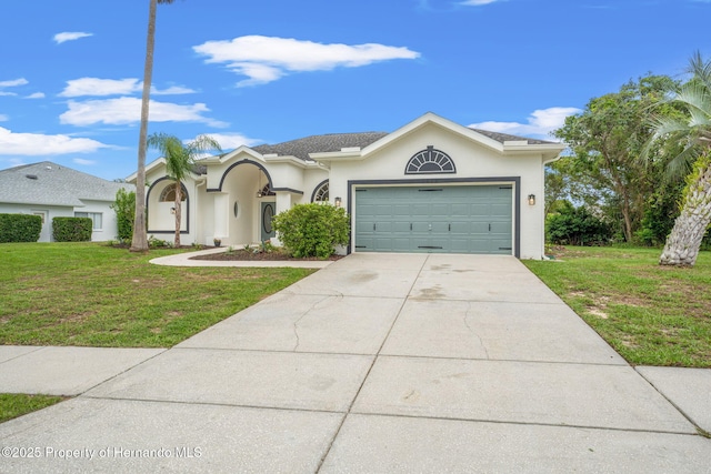 view of front of property with a front yard, stucco siding, driveway, and an attached garage