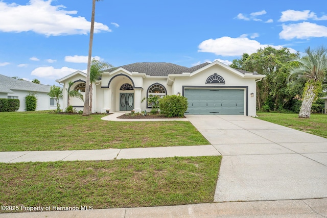 view of front of property featuring a garage, a front yard, driveway, and stucco siding