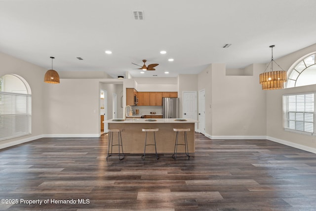 kitchen featuring freestanding refrigerator, brown cabinetry, recessed lighting, baseboards, and light countertops
