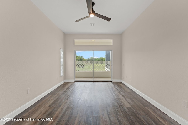 unfurnished room featuring dark wood-style flooring, ceiling fan, and baseboards