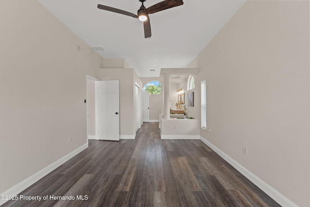 unfurnished room with ceiling fan, dark wood-type flooring, and baseboards