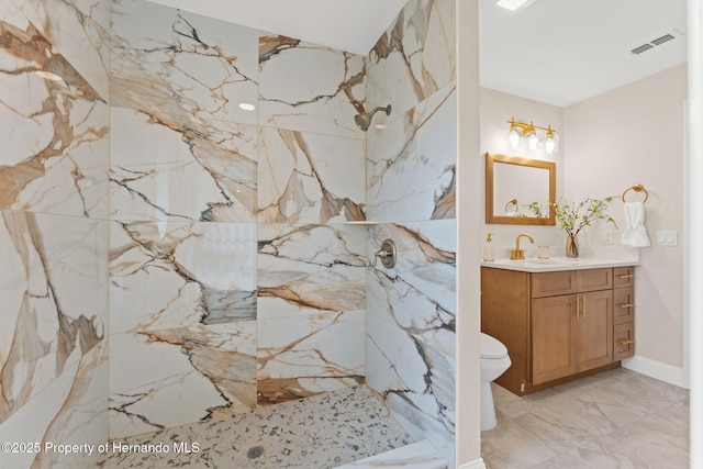 bathroom with a marble finish shower, vanity, marble tiled floors, and toilet