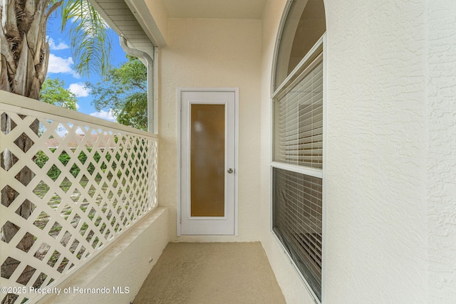 property entrance with stucco siding and fence