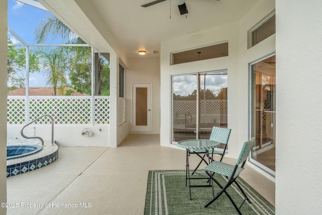sunroom / solarium with ceiling fan and a hot tub