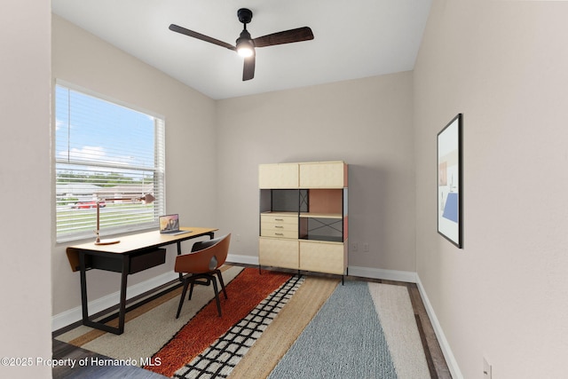 home office featuring a ceiling fan and baseboards