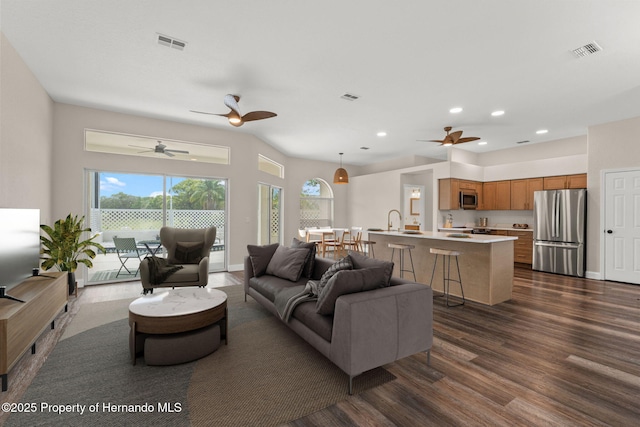 living area with dark wood finished floors, ceiling fan, and recessed lighting
