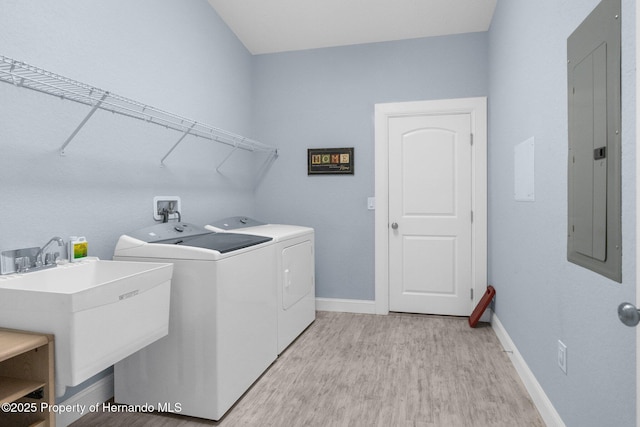 4960 Hidden Knob Trl, Spring Hill, FL 34609 - washroom featuring electric panel, washer and clothes dryer, light wood-style flooring, and baseboards