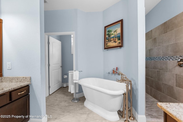 4960 Hidden Knob Trl, Spring Hill, FL 34609 - bathroom with a freestanding bath, wood finished floors, a walk in shower, vanity, and baseboards