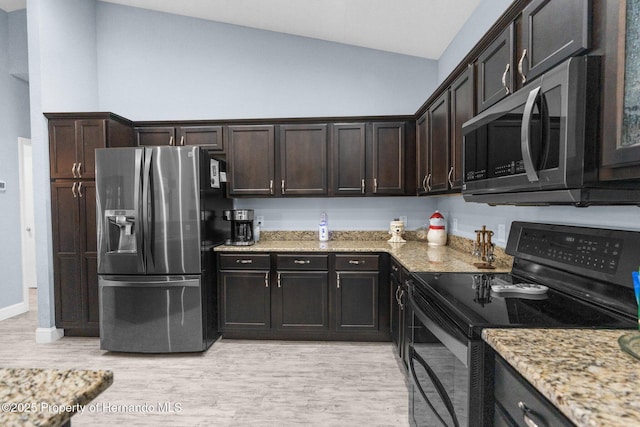 4960 Hidden Knob Trl, Spring Hill, FL 34609 - kitchen with appliances with stainless steel finishes, vaulted ceiling, light wood-type flooring, light stone counters, and dark brown cabinets