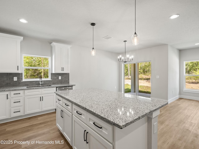 14353 Chimney Swift Rd, Weeki Wachee, FL 34614 - kitchen with a sink, tasteful backsplash, recessed lighting, a kitchen island, and light wood-type flooring