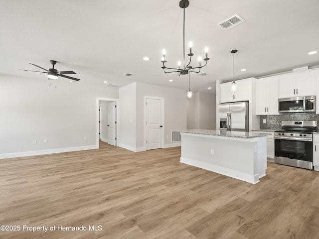 14353 Chimney Swift Rd, Weeki Wachee, FL 34614 - kitchen featuring stainless steel appliances, recessed lighting, tasteful backsplash, a kitchen island, and light wood-style floors