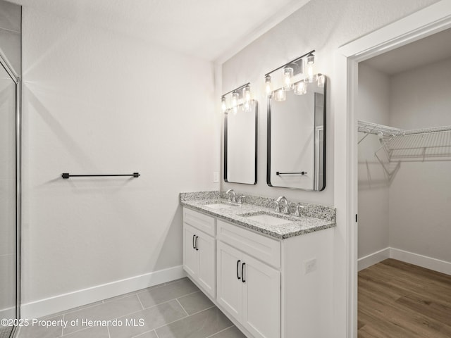 14353 Chimney Swift Rd, Weeki Wachee, FL 34614 - full bathroom featuring baseboards, a spacious closet, and double vanity