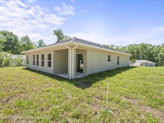 14353 Chimney Swift Rd, Weeki Wachee, FL 34614 - rear view of property with stucco siding, a lawn, and a patio area
