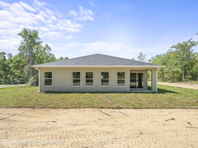 14353 Chimney Swift Rd, Weeki Wachee, FL 34614 - rear view of property featuring stucco siding, a yard, and roof with shingles