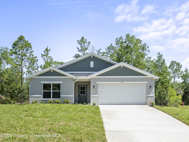 14353 Chimney Swift Rd, Weeki Wachee, FL 34614 - view of front of house featuring a garage, concrete driveway, a front lawn, and stucco siding
