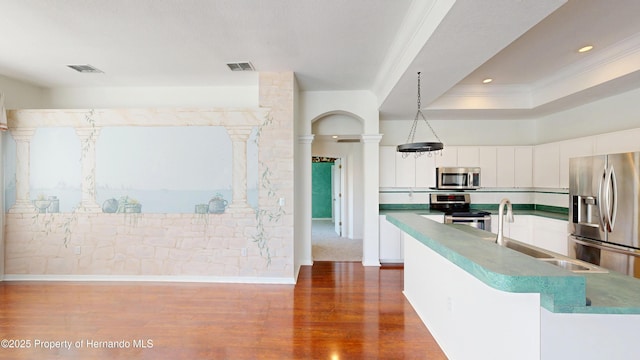 4048 St Ives Blvd, Spring Hill, FL 34609 - kitchen featuring appliances with stainless steel finishes, ornate columns, dark wood finished floors, white cabinetry, and crown molding